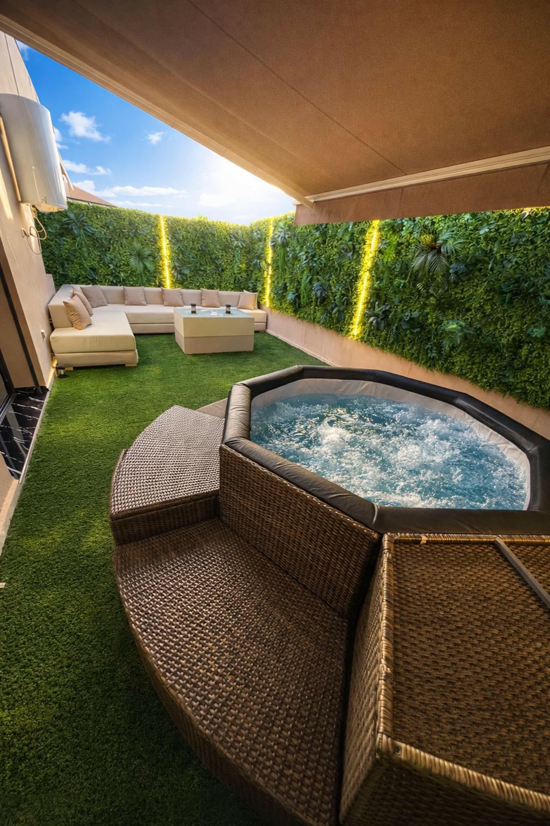 Terrasse avec jacuzzi et grand salon d'extérieur