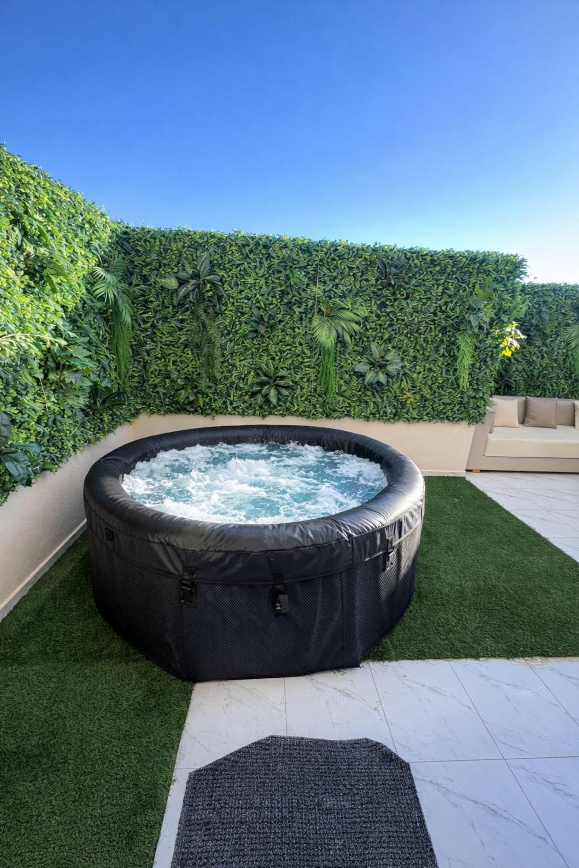 Heated jacuzzi in front of the green wall